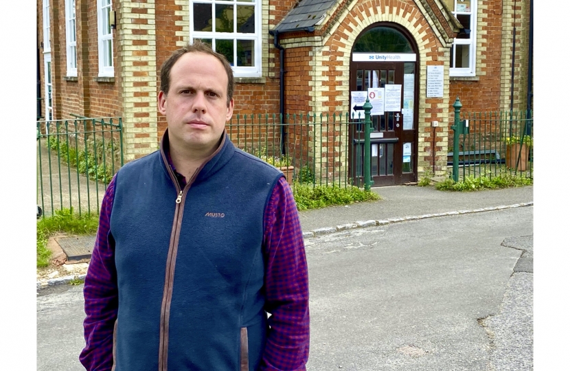 Greg is stood outside the Long Crendon Surgery building in late-August 2020