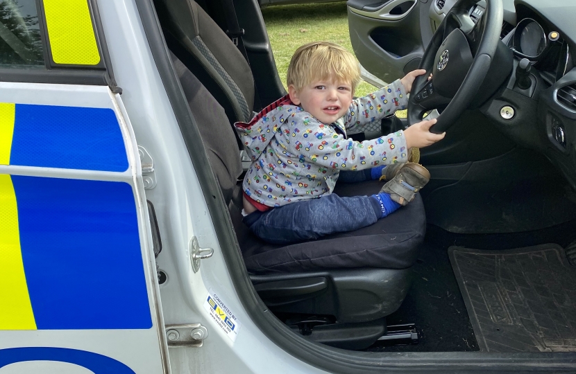Greg's son sitting in a Police car at the event.